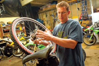 Todd Costley works on a bike at his business on Tuesday. Costley's shop, which goes by the name Sports World,is one of two new bike shops to open in Gallup recently. © 2011 Gallup Independent / Brian Leddy 